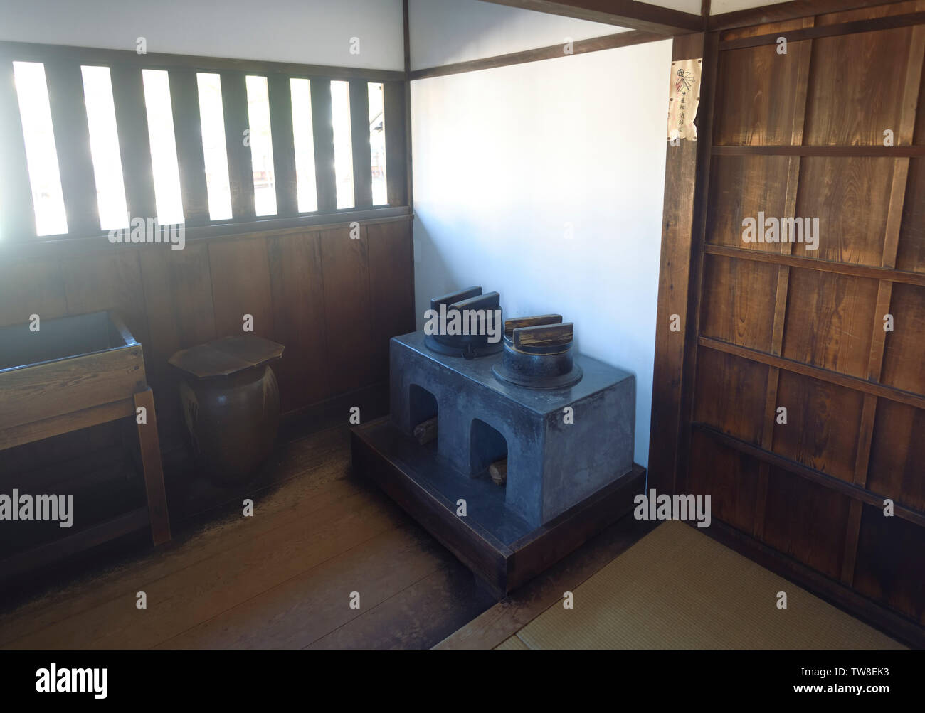 Angolo cottura nel tradizionale giapponese del periodo Edo edificio storico interno. Stufa in una piccola illuminata con luce solare cucina di Takayama Jinya house, Takayam Foto Stock
