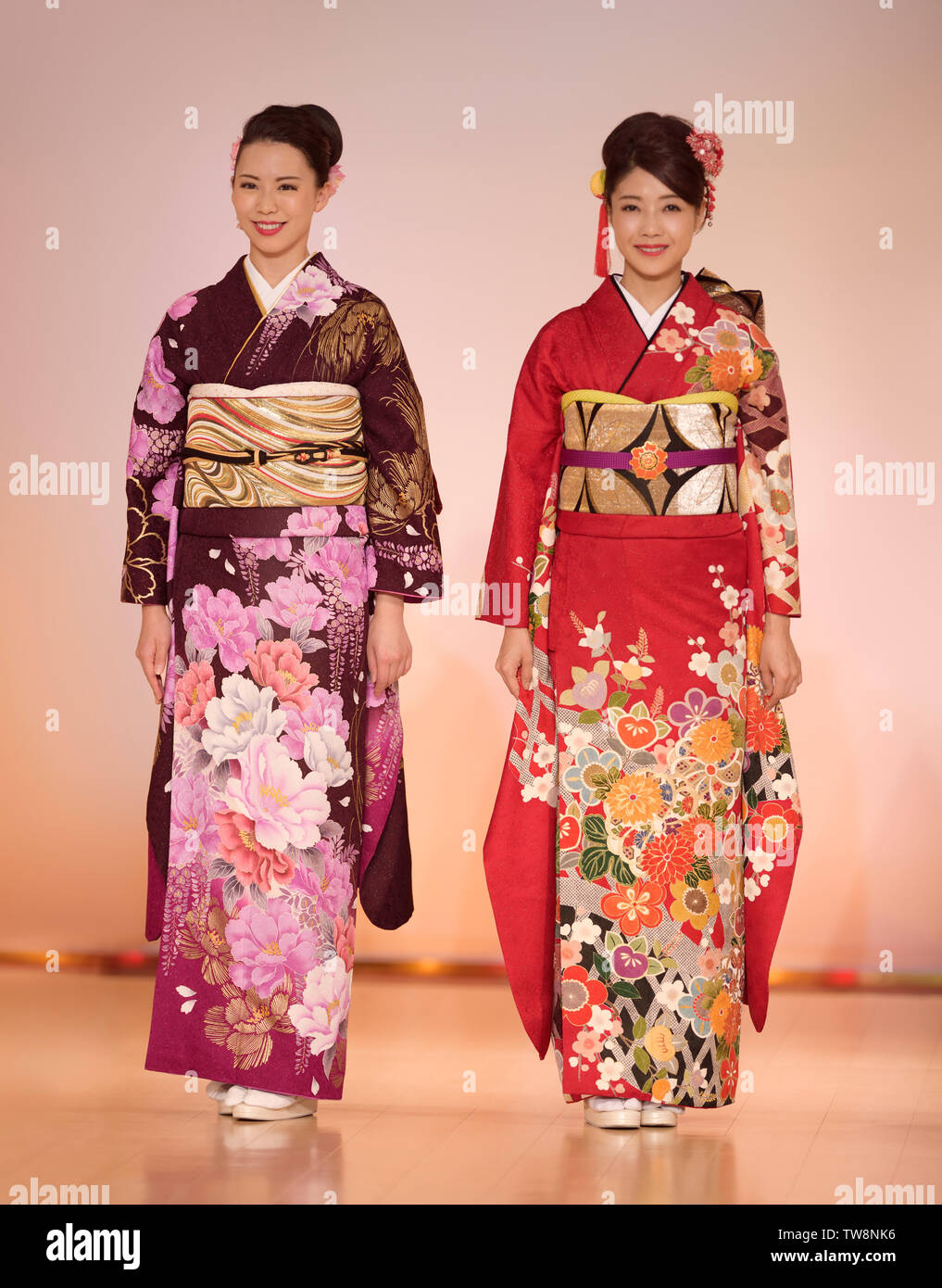 Licenza disponibile alle MaximImages.com:00 - Signore giapponesi in uno splendido kimono rosso e viola colorato con design floreale in una sfilata di moda a Kyoto Foto Stock