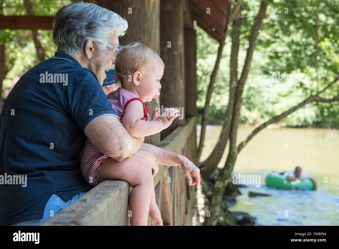 Una bambina e la sua bisnonna guardare i tuberi di una deriva verso il basso il fiume Chattahoochee in Helen, Georgia. (USA) Foto Stock