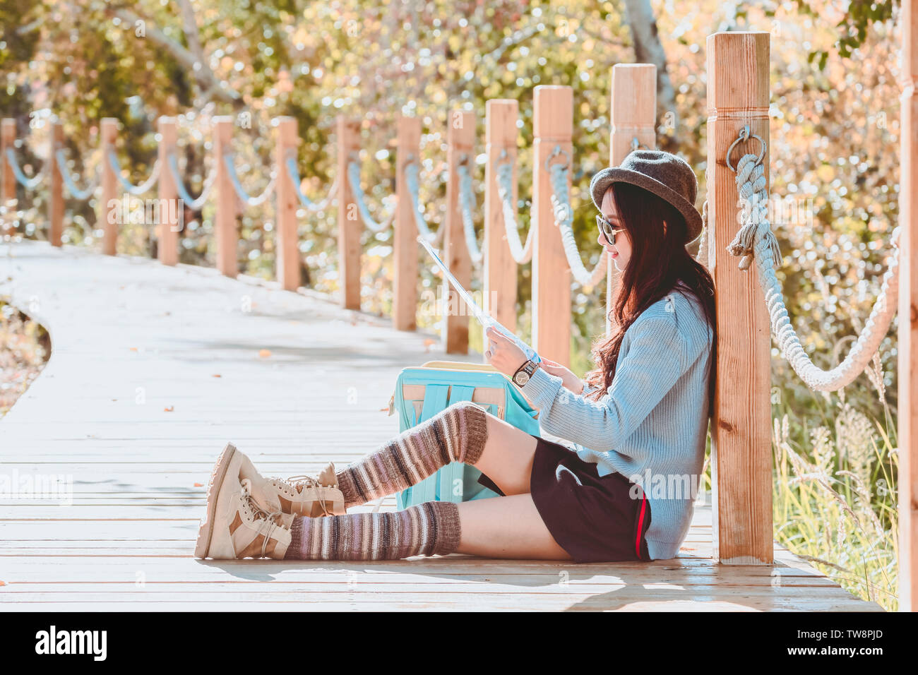 Ragazza seduta su un viaggio alla ricerca di una mappa Foto Stock