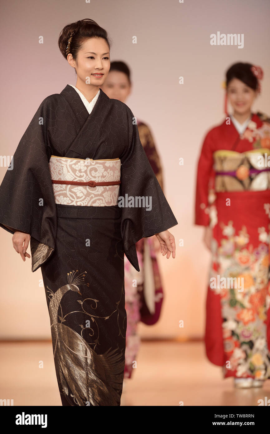 Licenza disponibile presso MaximImages.com donne giapponesi che indossano un elegante kimono nero con design argentato e obi in una sfilata di moda a Kyoto, Giappone. Foto Stock