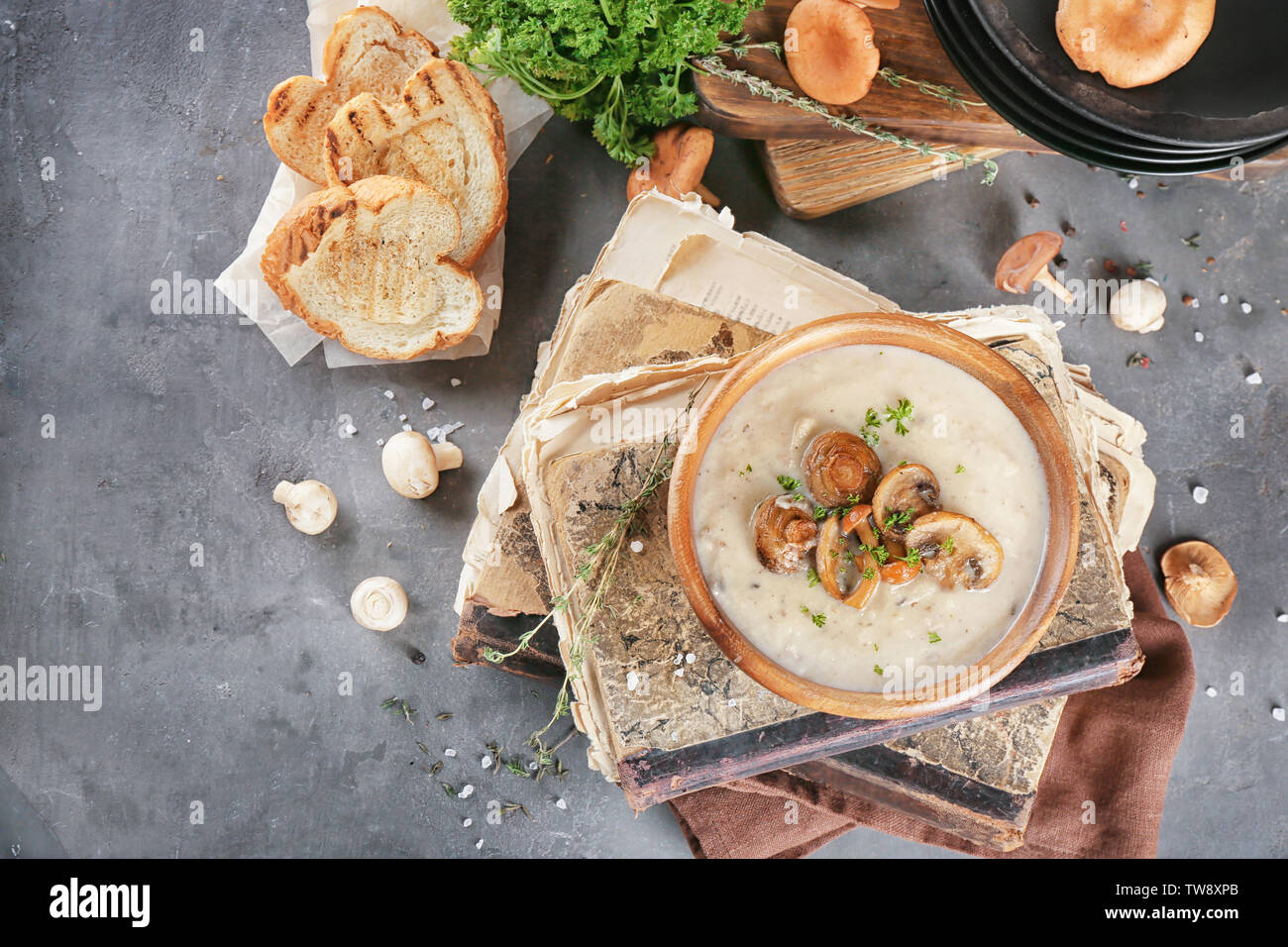 Ciotola con zuppa di funghi su libri antichi Foto Stock