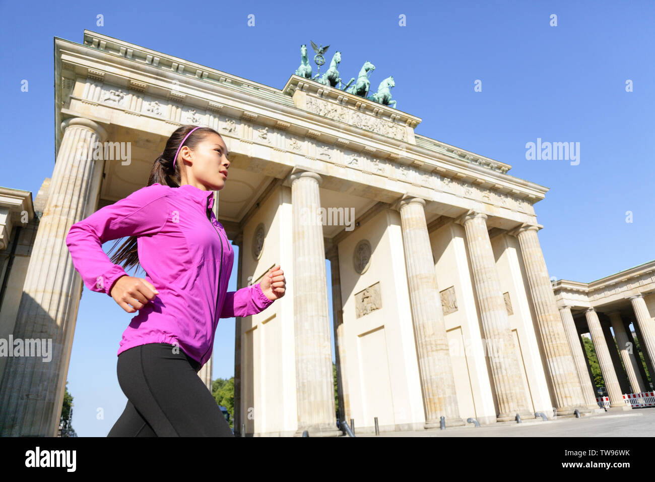 Esecuzione di donna di Berlino in Germania dalla Porta di Brandeburgo jogging vivere uno stile di vita sano. Femmina jogging runner. Urbano ragazza fitness lavoro fuori all'aperto nella camicia. Foto Stock