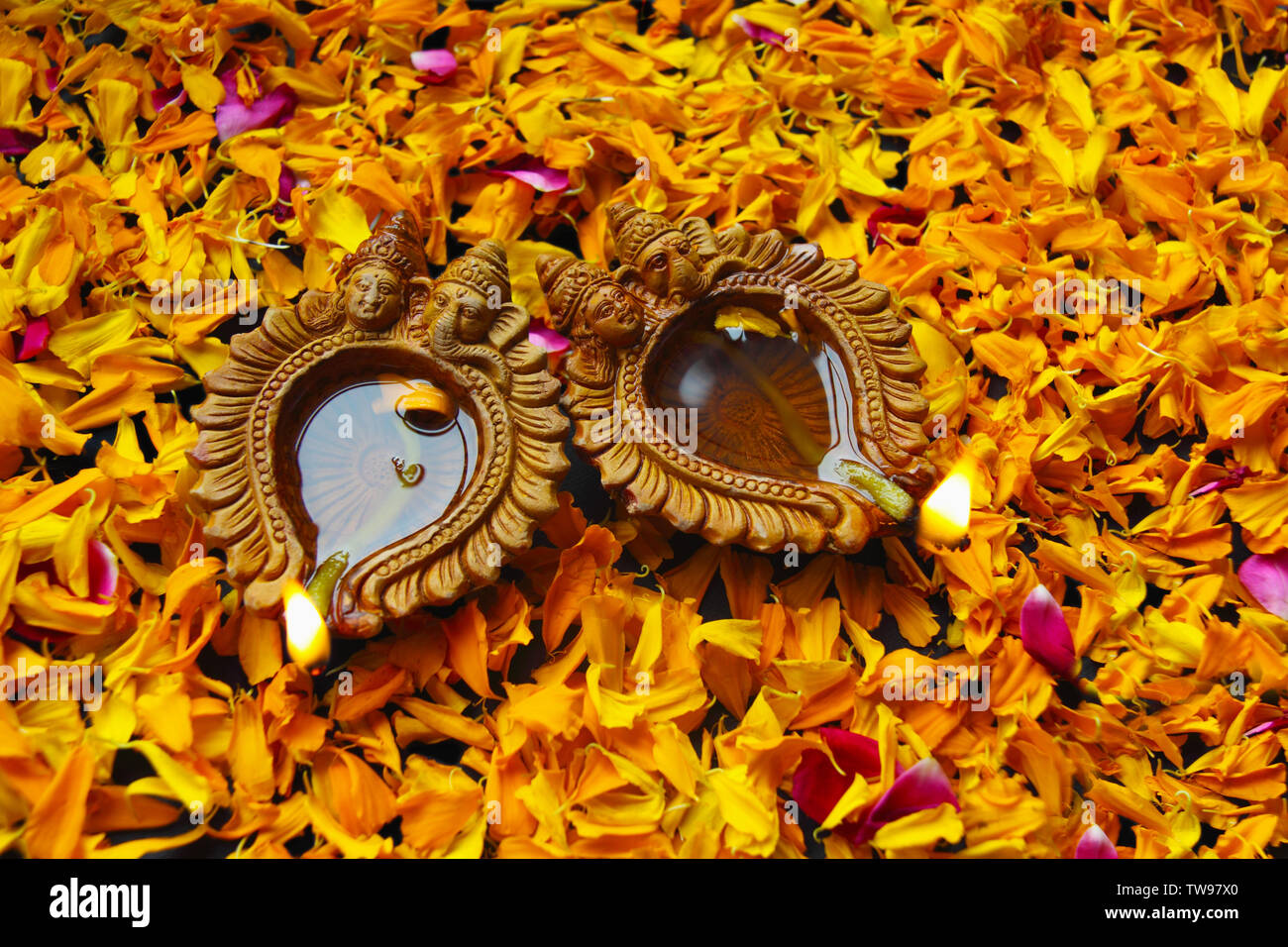 Primo piano di diwali bruciare diya con petali Foto Stock