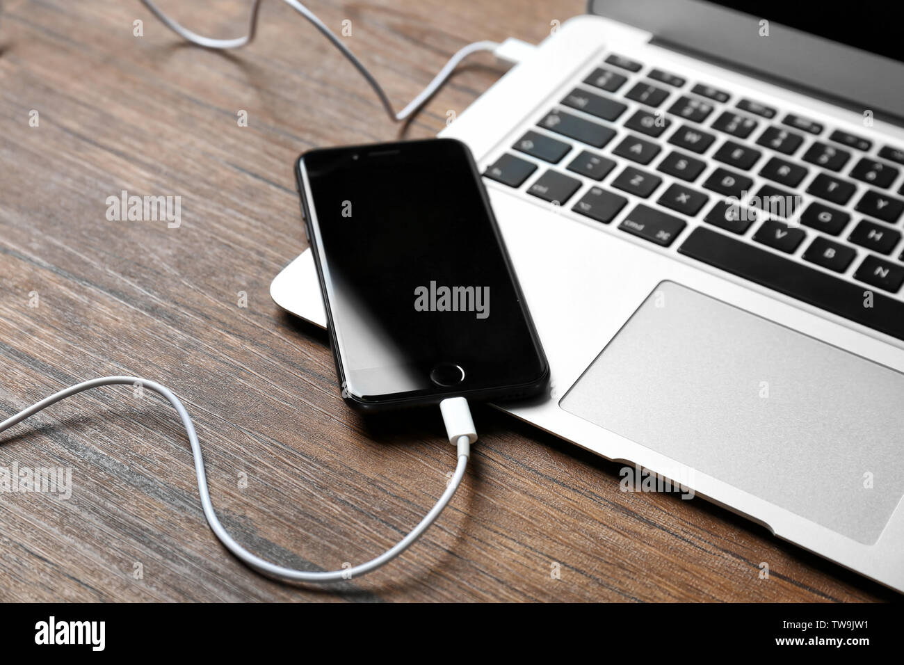 Kiev, Ucraina - 18 dicembre 2017: iPhone 8 spazio grigio collegato al laptop sul tavolo Foto Stock