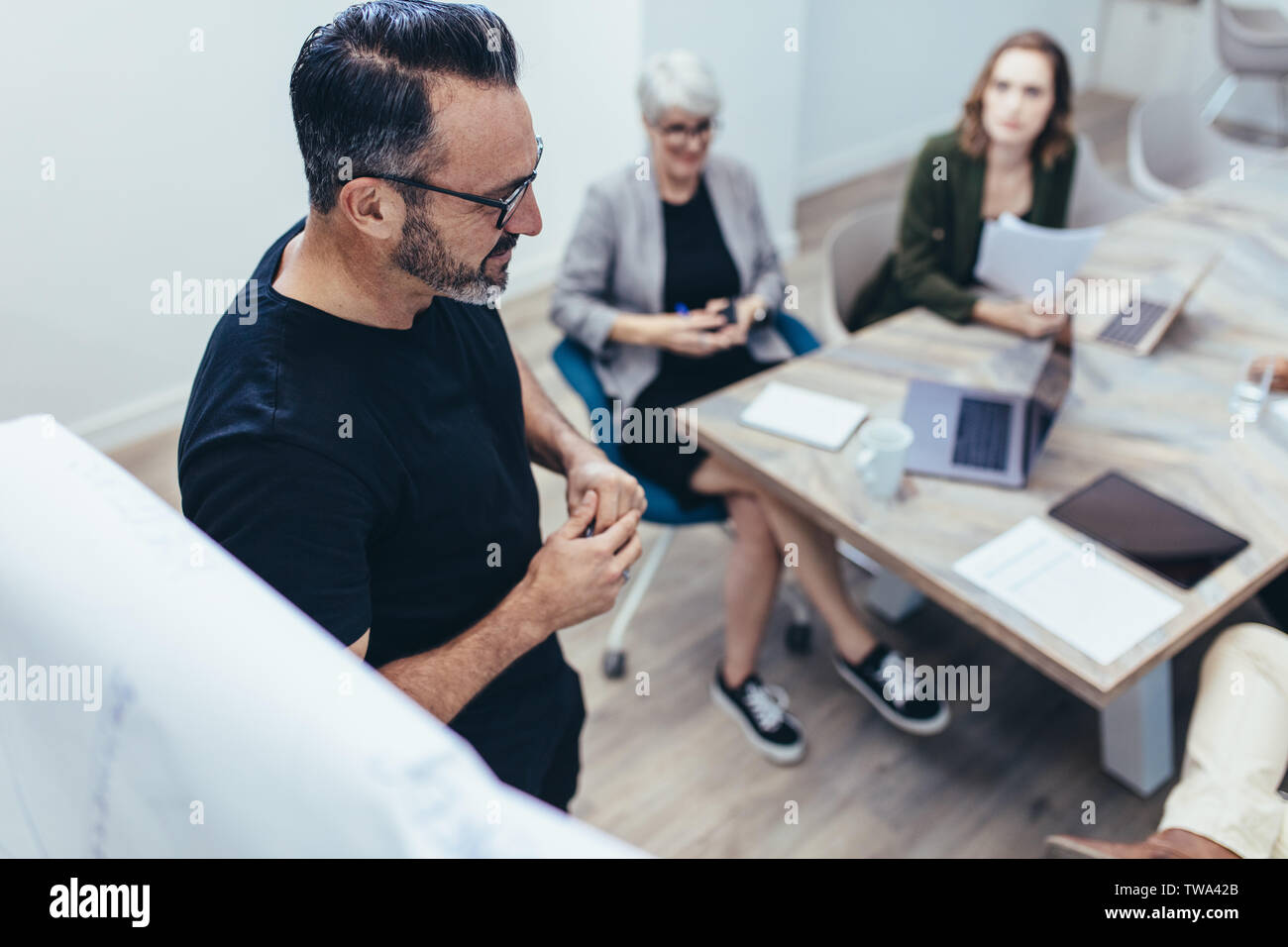 Imprenditore maturo condividendo le sue idee ai colleghi durante la presentazione. Maschio dando professionale presentazione per il suo team seduti nella sala conferenze a Foto Stock