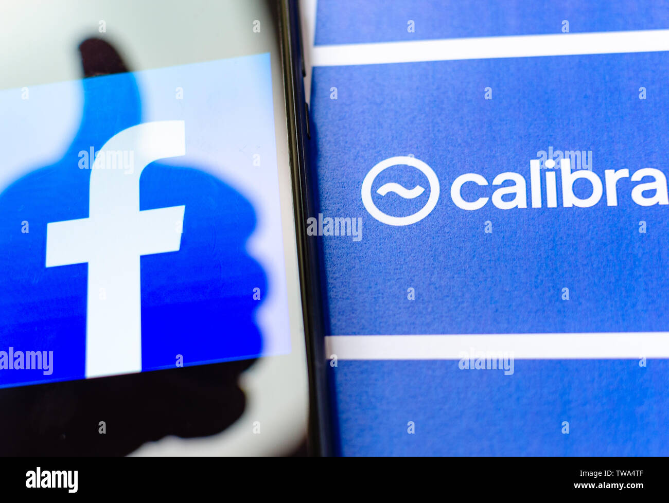 Logo di Facebook sullo schermo e la brochure con Calibra logo. A titolo illustrativo per notizie su Facebook cryptocurrency e portafogli digitale app. Foto Stock