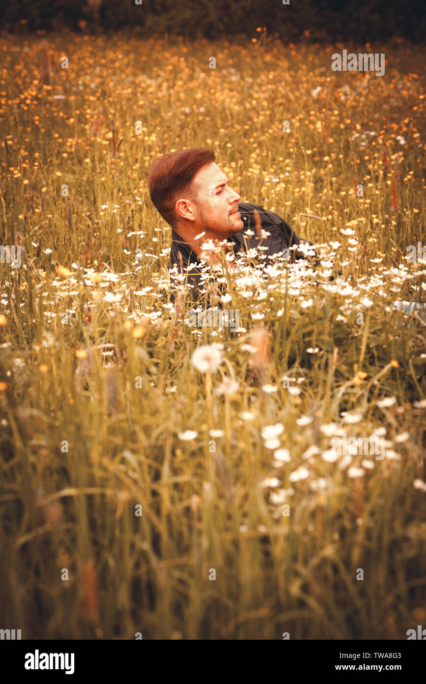 Giovane uomo che guarda lontano nel campo Foto Stock