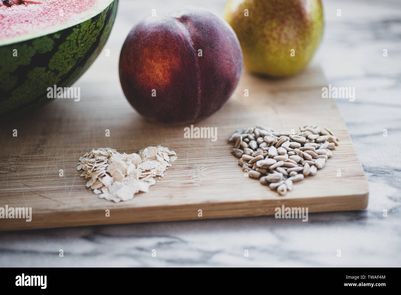 Pera, pesca, chicchi d' avena, su una tavola di legno Foto Stock