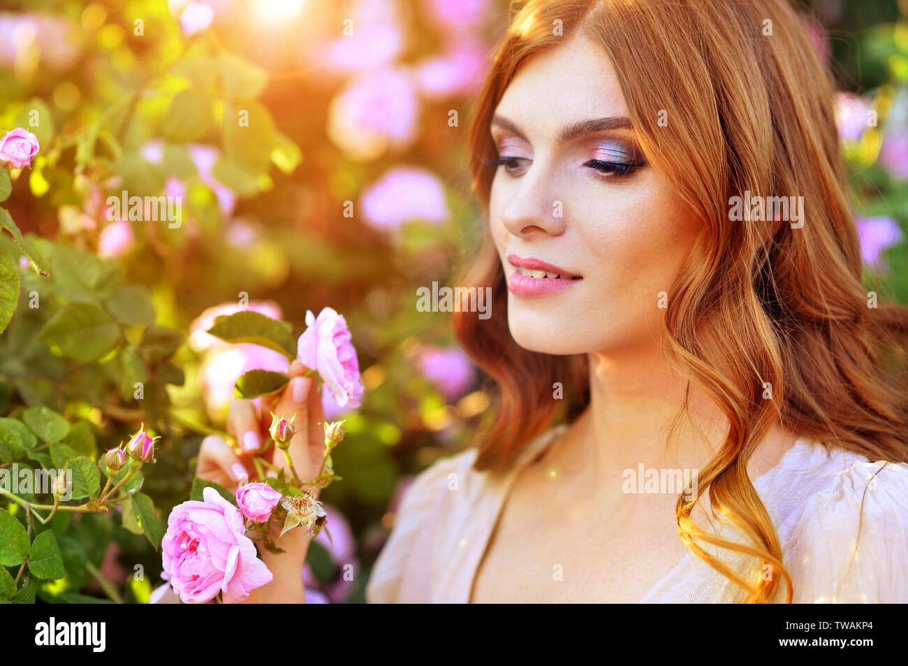 Ritratto di giovane e bella donna in posa da rose bush Foto Stock
