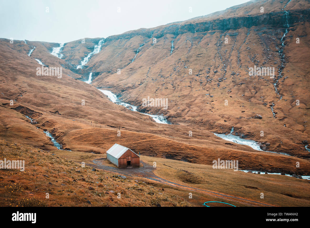 Le montagne e le cascate in una zona rurale di ​​the Isole Faerøer. Foto Stock
