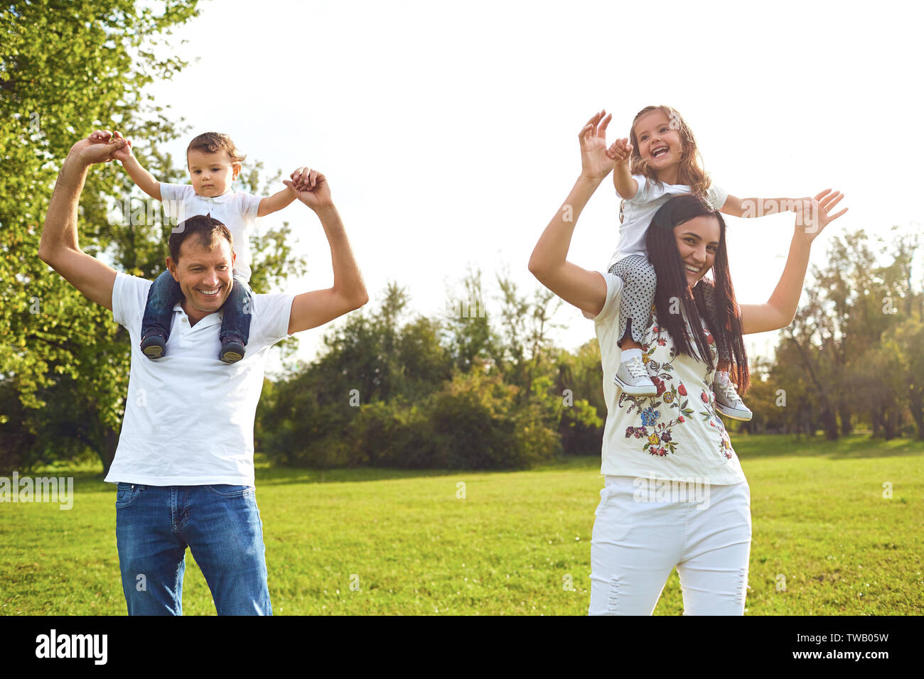 Famiglia con bambini che giocano sull'erba nel parco. Foto Stock