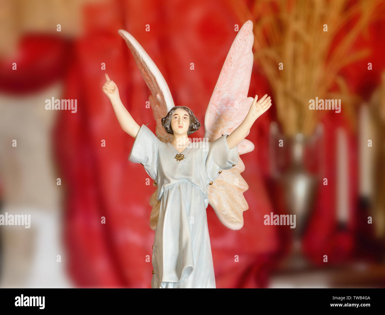 Una femmina di Art Nouveau angel in una cappella, con le braccia e le mani in alto, grandi ali rovesciate, piccola statuetta in porcellana. Lo sfondo in rosso scuro, v Foto Stock
