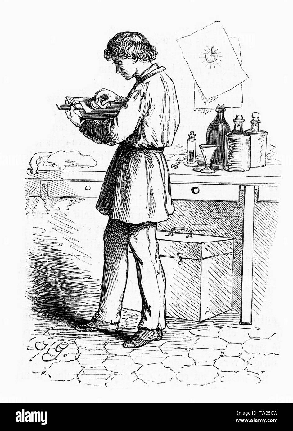 Un giovane uomo si prepara una lastra di vetro per esposizione fotografica all'interno di un workshop. Data: 1863 Foto Stock