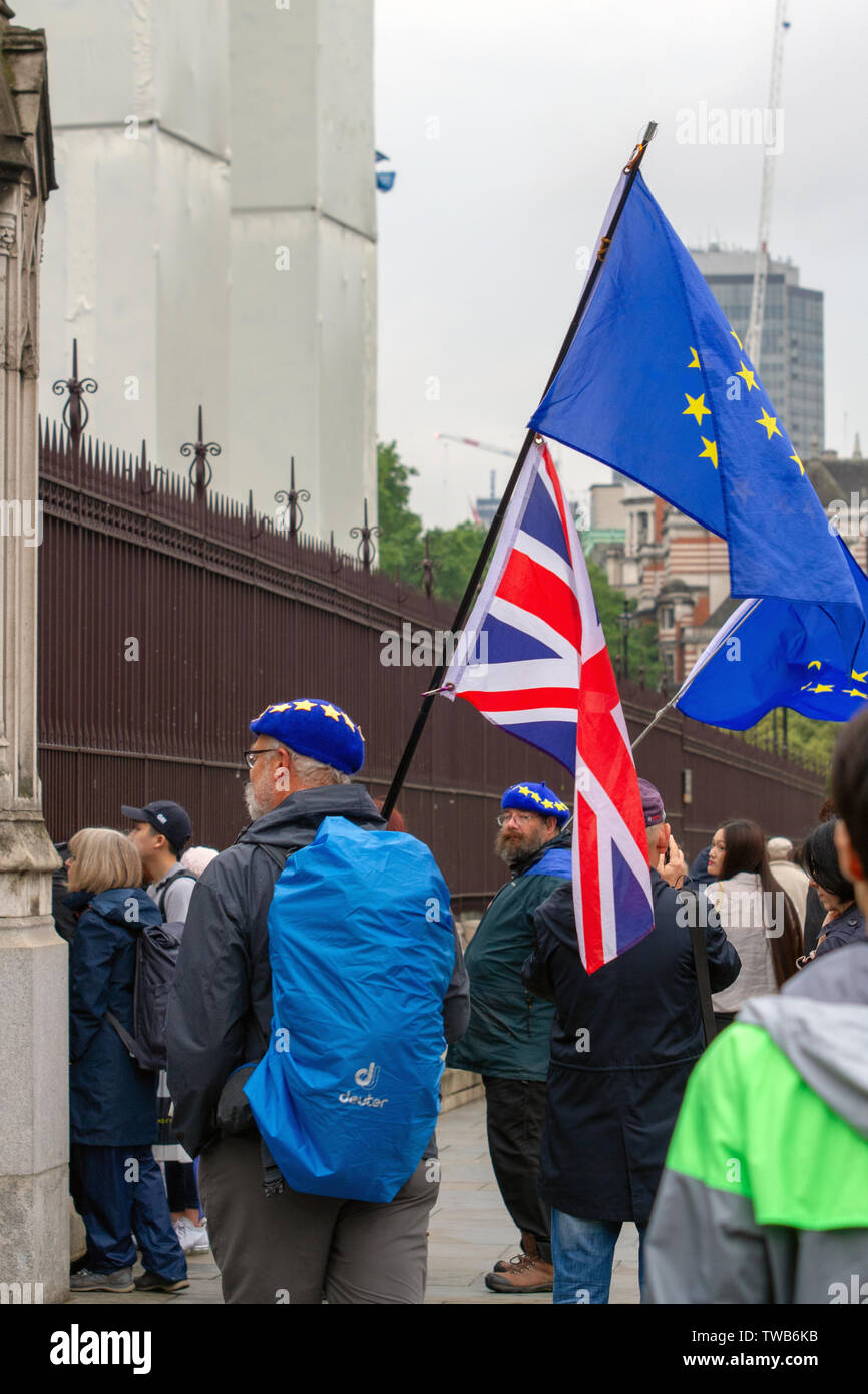 Un manifestante trattiene le bandiere durante la dimostrazione.Anti-Brexiteers hanno protestato fuori le case del Parlamento come un voto per la direzione del partito conservatore ha avuto luogo. Manifestanti hanno tenuto grandi bandiere, cartelloni, e gridò al pro-Brexit membri del Parlamento. Guide di scorrimento per diventare il prossimo Primo ministro sono Boris Johnson, Jeremy Hunt, Michael Gove, Rory Stewart e Sajid Javid, più successivamente ha preso parte a un dibattito teletrasmesso alla BBC di nuovo Broadcasting House. Gli attivisti ha suonato musica forte come MPs sono stati intervistati sulla fotocamera. Foto Stock