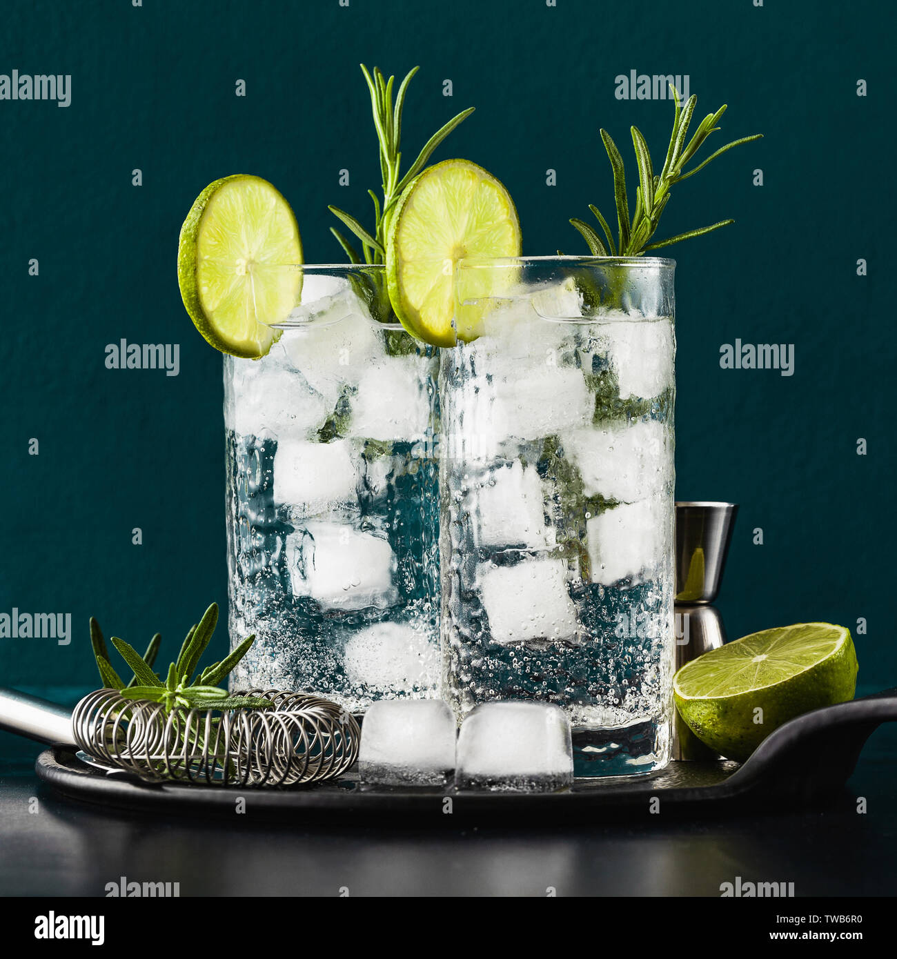 Classic gin tonic cocktail con rametti di rosmarino in bicchieri alti su un  tavolo con accessori bar Foto stock - Alamy