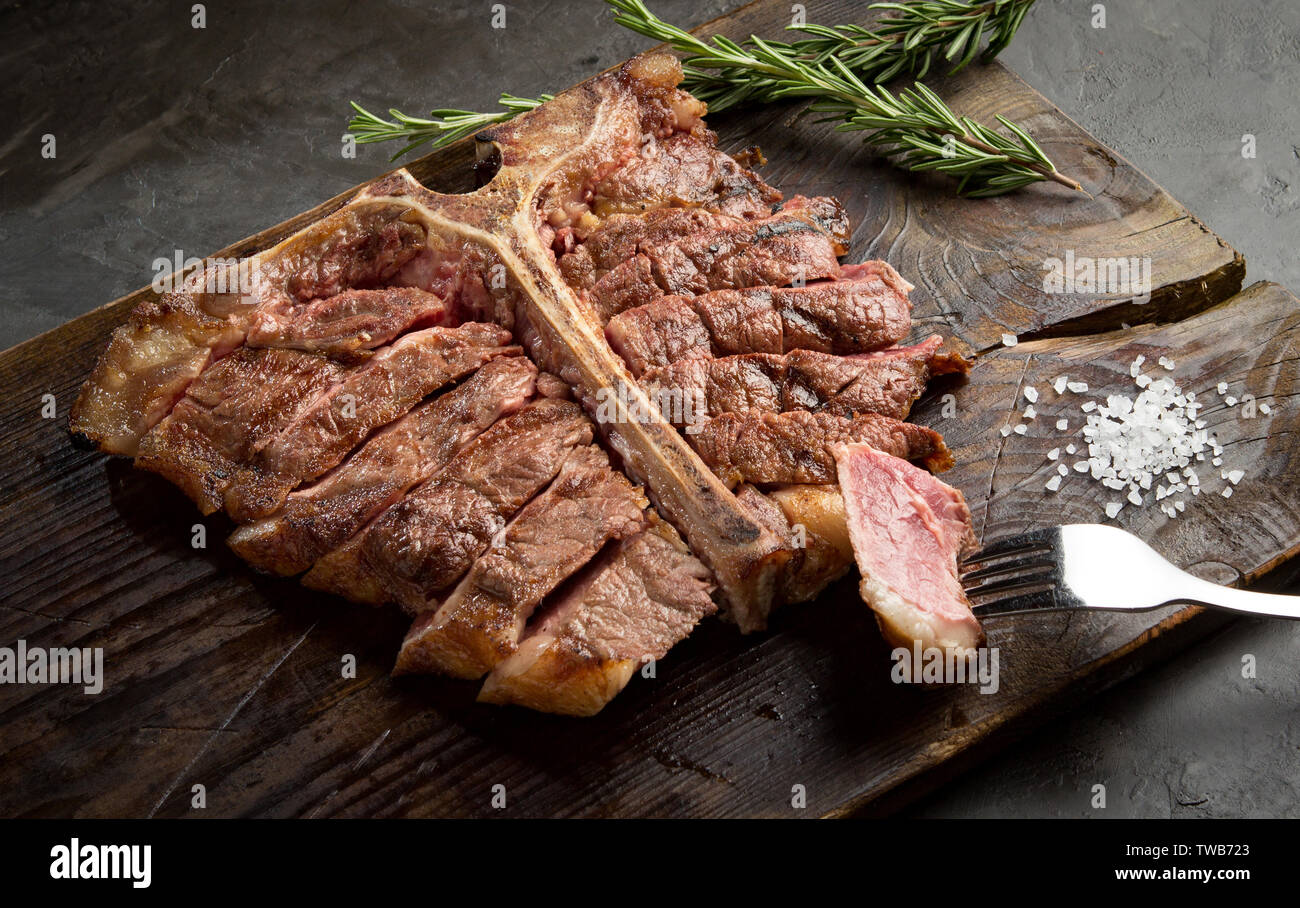 Osteria bistecca alla brace e affettato su un pezzo di legno. stile rustico, vista dall'alto Foto Stock