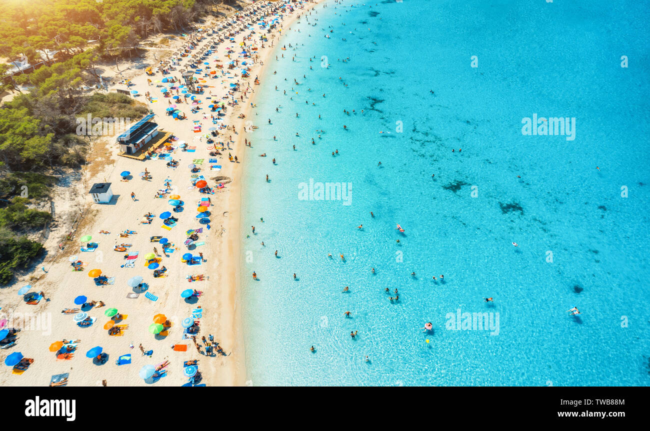 Vista aerea della spiaggia sabbiosa con ombrelloni colorati e mare Foto Stock