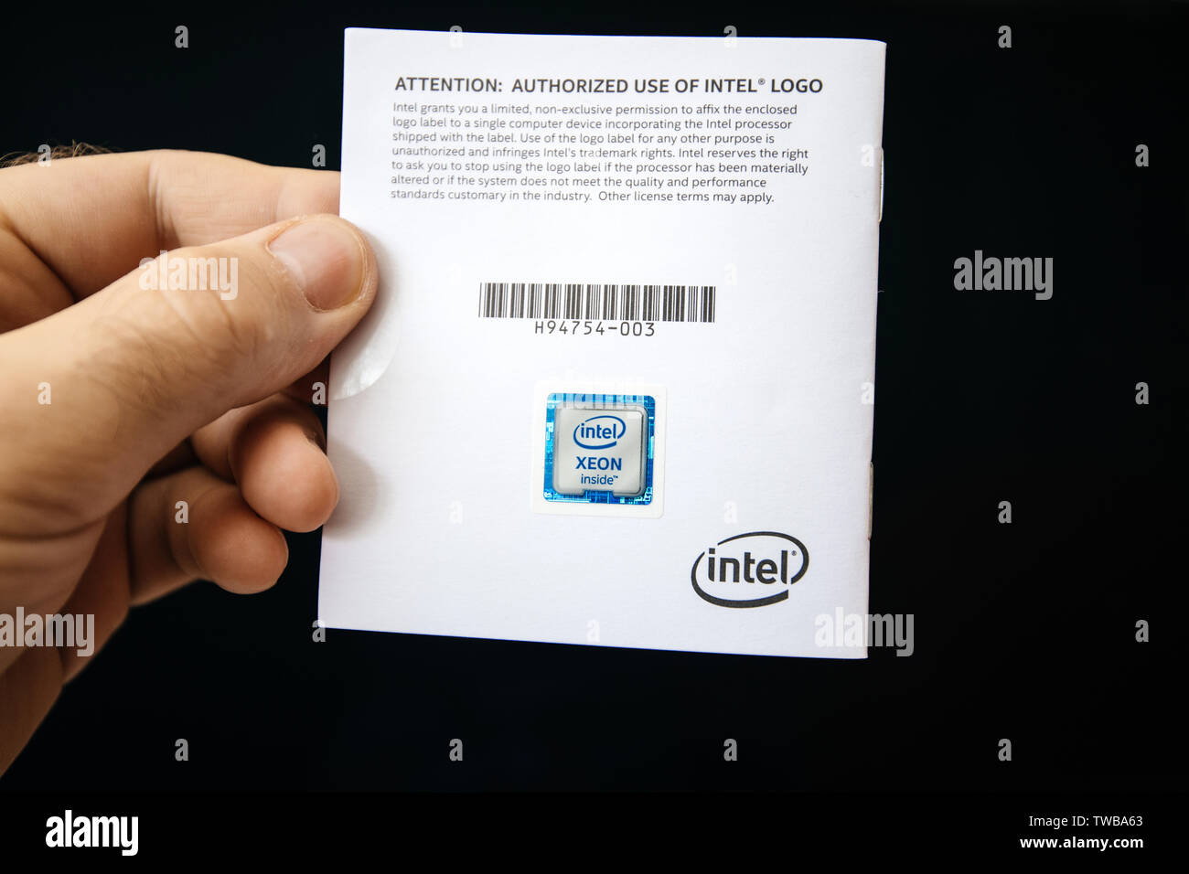 Parigi, Francia - giu 7, 2019: Man mano che tiene il manuale di istruzioni della Intel Xeon professional processore CPU su sfondo nero Foto Stock