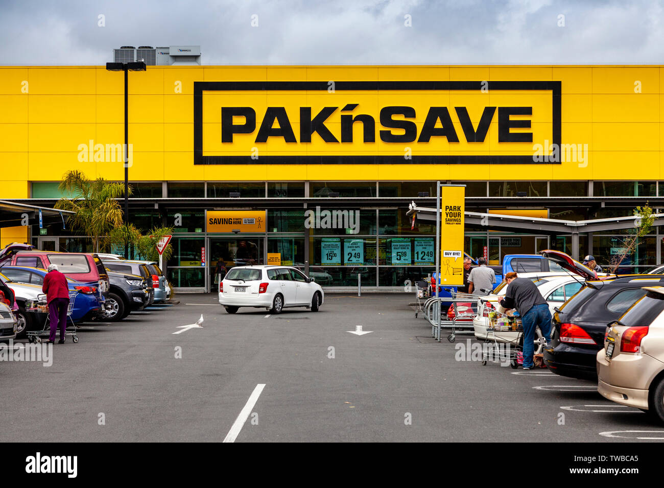 Persone caricando gli acquisti al supermercato PaknSave, Whangarei, Isola del nord, Nuova Zelanda Foto Stock