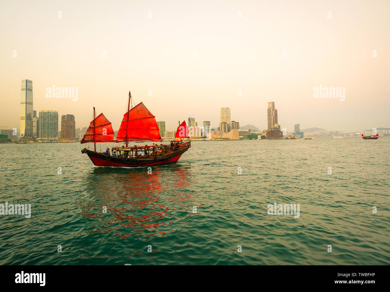 Porto di Hong kong e sullo skyline, indesiderata rosso in barca a vela in primo piano Foto Stock