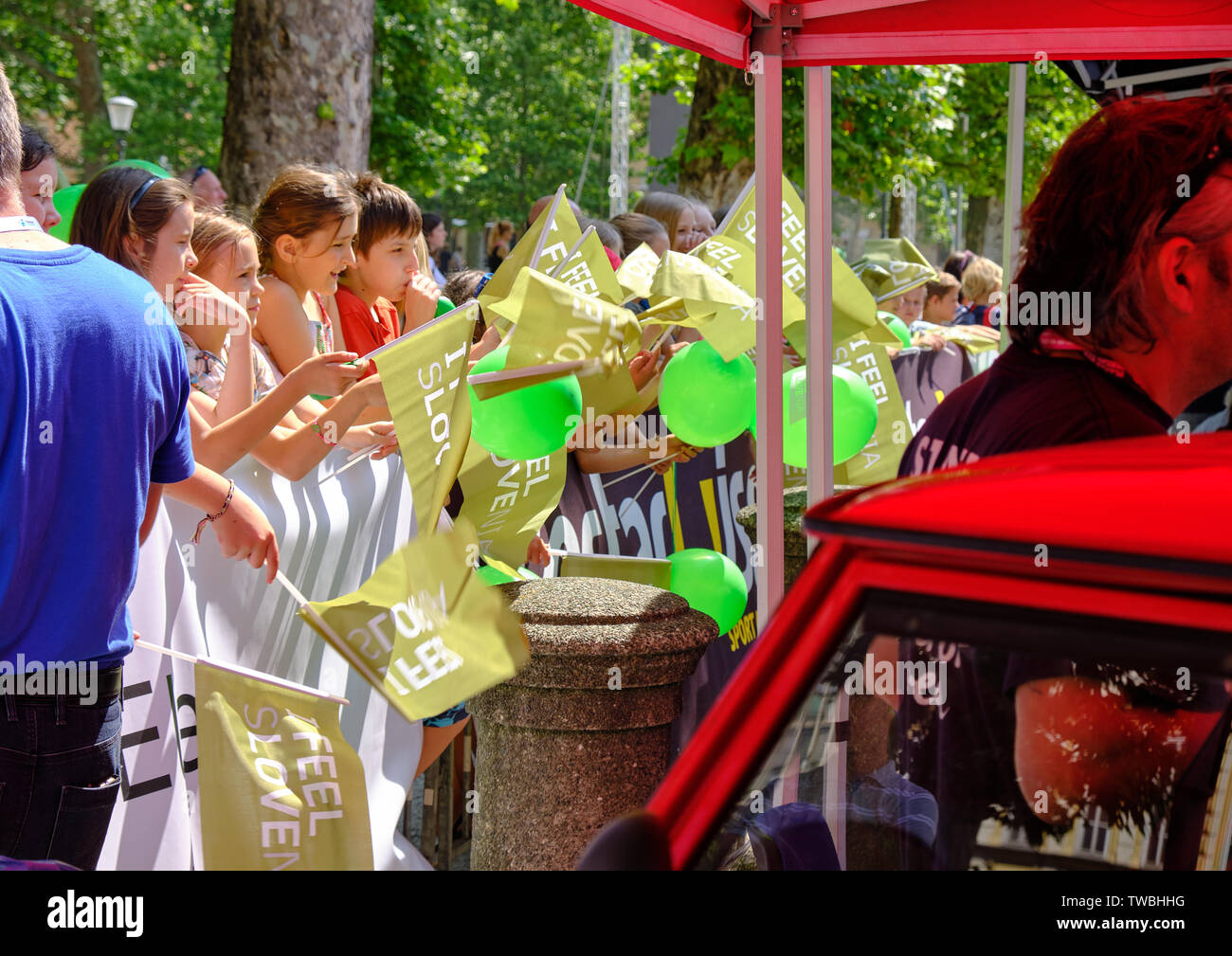 Bambini il tifo e agitando ' mi sento della sLOVEnia " bandiere alla partenza del tour di Slovenia tappa una gara, Lubiana, Slovenia - 19 giugno 2019 Foto Stock