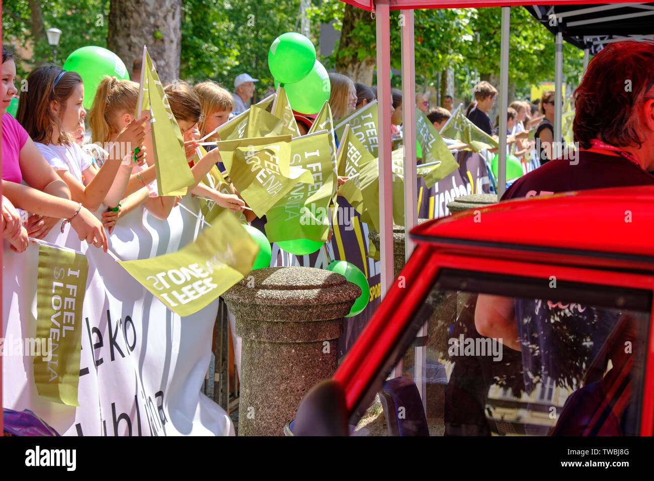 Bambini il tifo e agitando ' mi sento della sLOVEnia " bandiere alla partenza del tour di Slovenia tappa una gara, Lubiana, Slovenia - 19 giugno 2019 Foto Stock