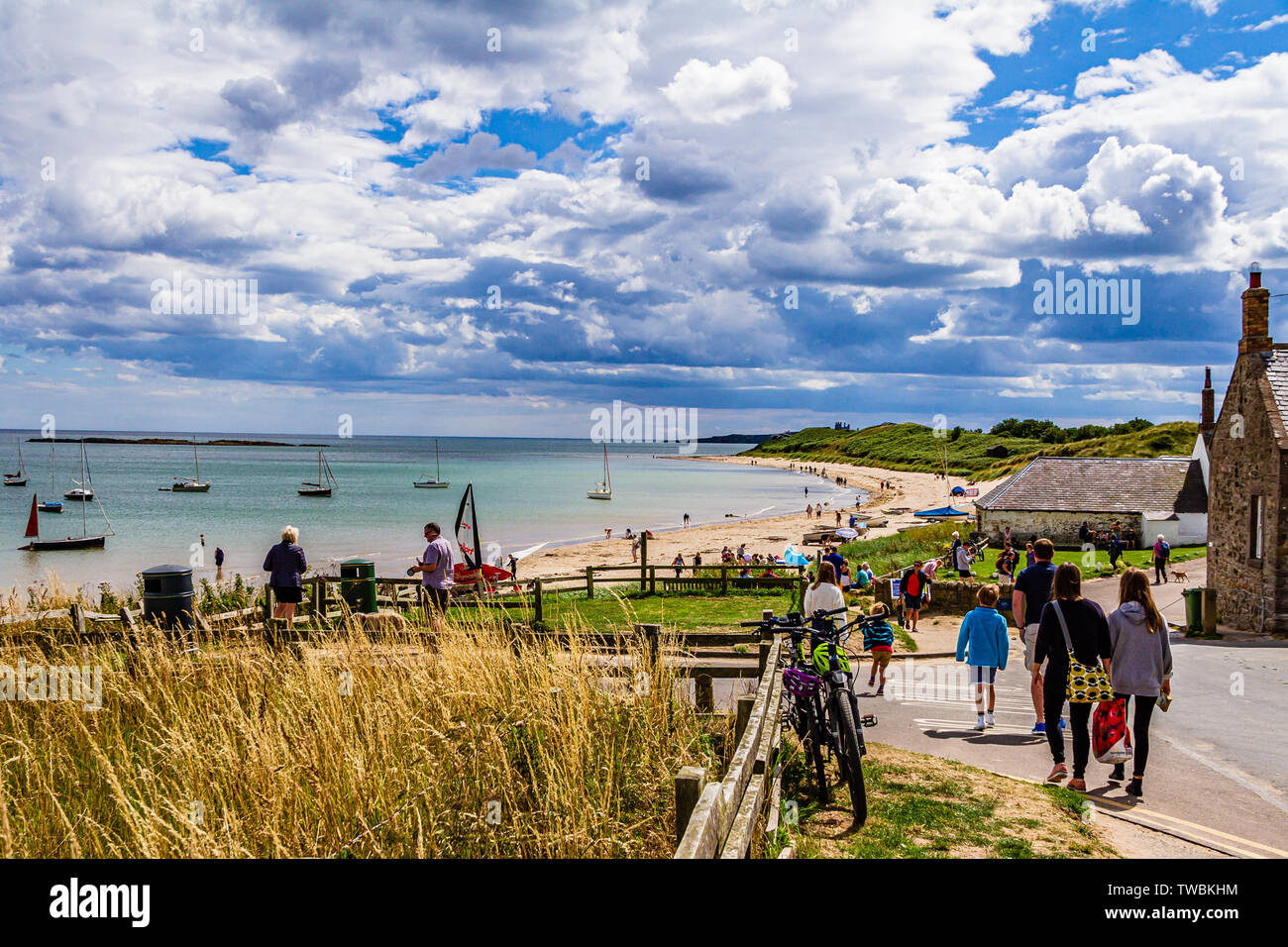 La gente di andare in spiaggia su una soleggiata giornata estiva a bassa Newton-per-il-Mare, Northumberland, Regno Unito. Agosto 2018. Foto Stock