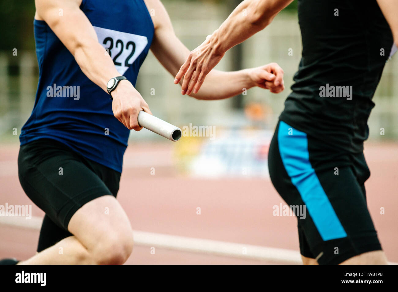 Staffetta uomini atleti corridori passando il testimone la concorrenza di atletica leggera Foto Stock