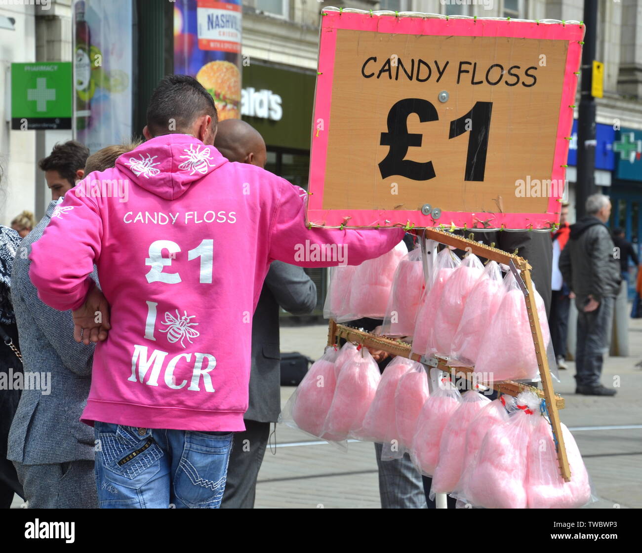 Un uomo in rosa e bianco giacca vende Candy Floss per £ 1 nel centro della città di Manchester, Regno Unito Foto Stock
