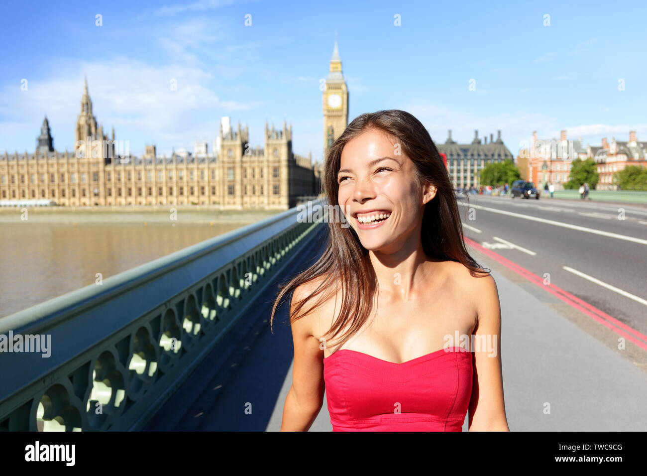 Londra donna felice d'estate. Candide sorridente ragazza dal Big Ben camminando sul Westminster Bridge, Londra, Inghilterra, Regno Unito. Turismo itinerante il concetto di stile di vita con allegra gara di misto asiatico femmina caucasica. Foto Stock