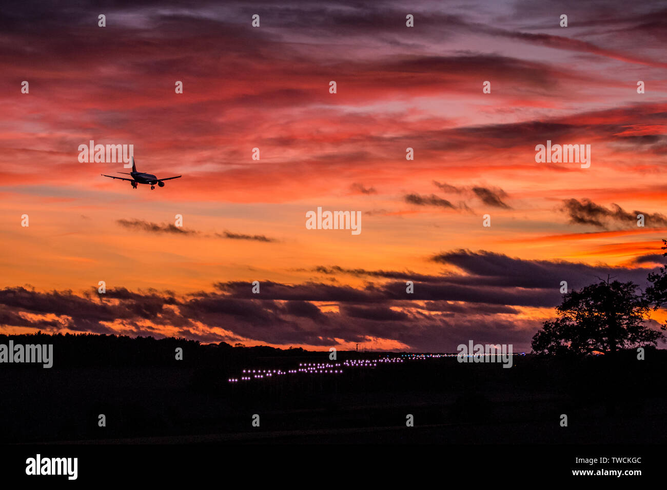 Arrivo a terra al tramonto con le luci della pista Foto Stock