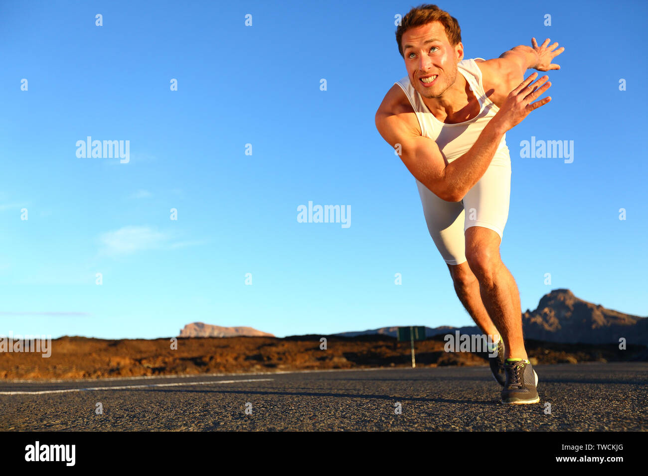 In volata running man. Runner sprinter in velocità della formazione verso gli obiettivi e il successo. Montare muscolare atleta maschio in allenamento all'aperto sulla strada. Foto Stock