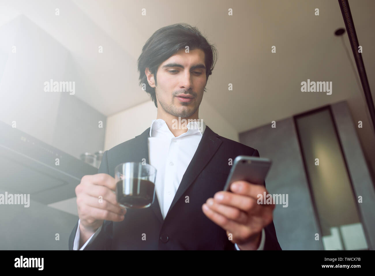 Imprenditore lavora con il suo smartphone a casa Foto Stock