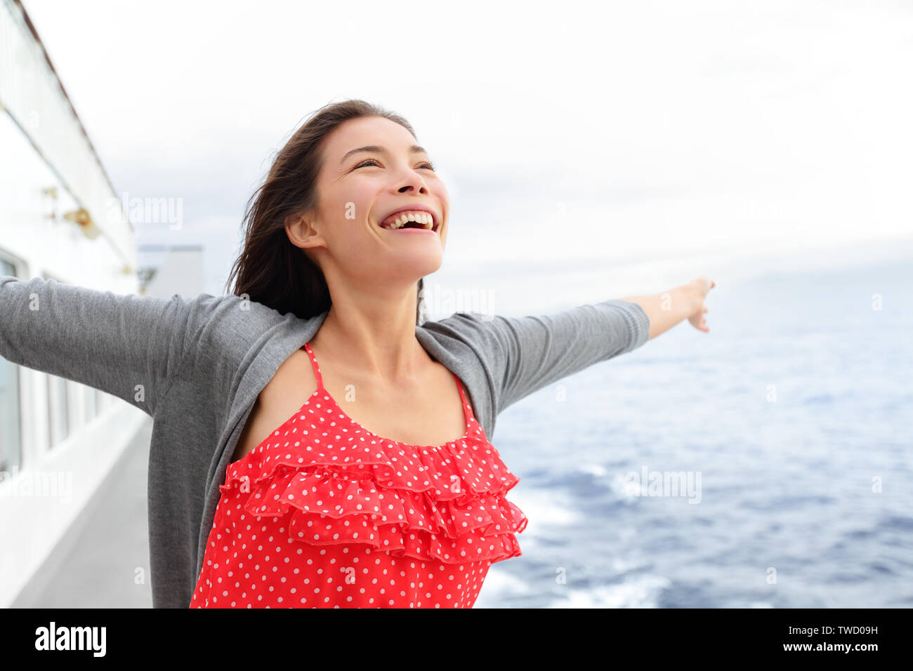La nave di crociera donna sulla barca in happy free pongono sorridente godendo della libertà. Giovane donna in viaggio per una vacanza in barca a vela in mare aperto oceano. Giovani razza mista asiatica donna caucasica. Foto Stock