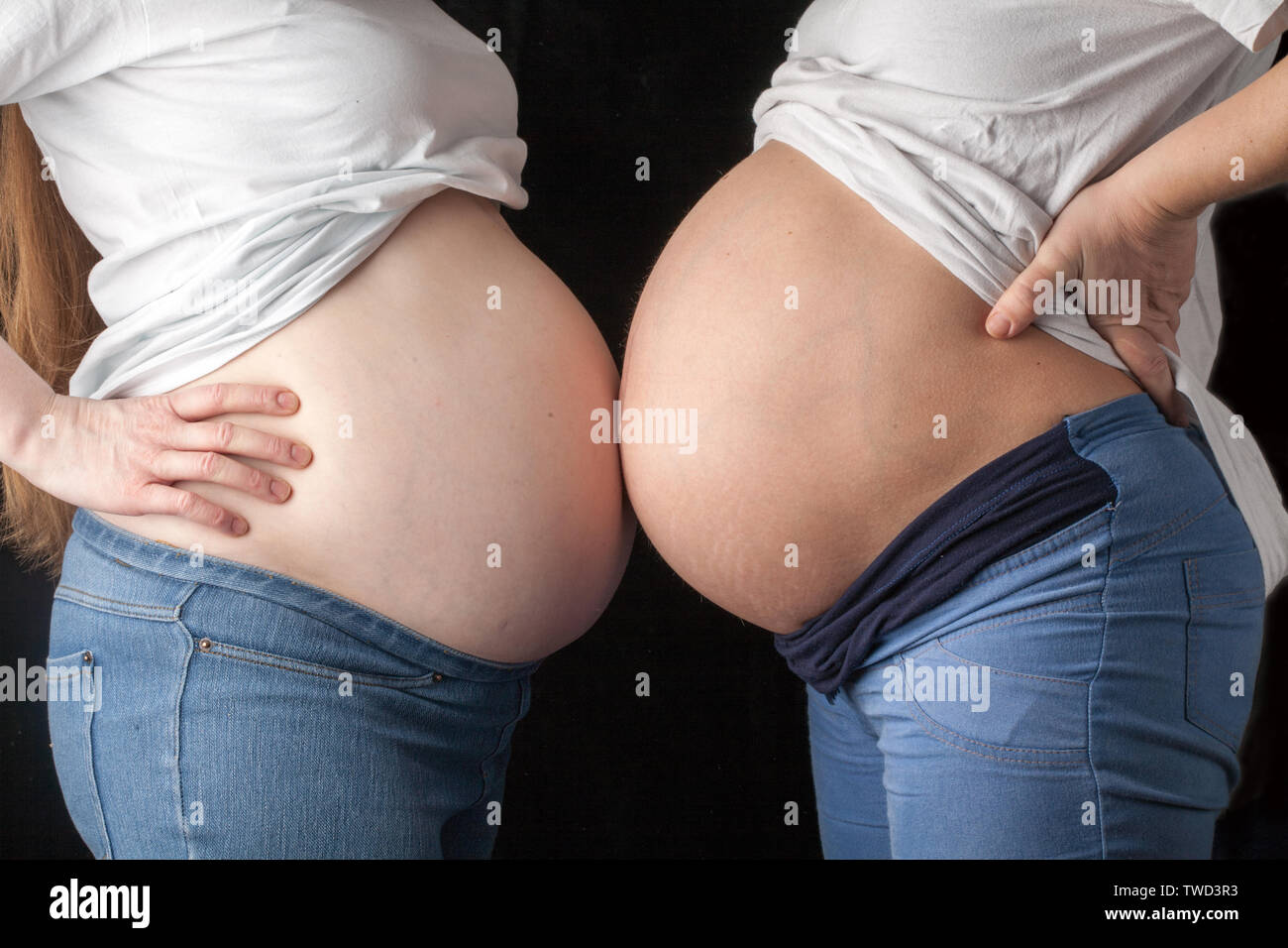 Due donne in stato di gravidanza pance in piedi di fronte a ogni altra vista laterale vista dettagliata Foto Stock