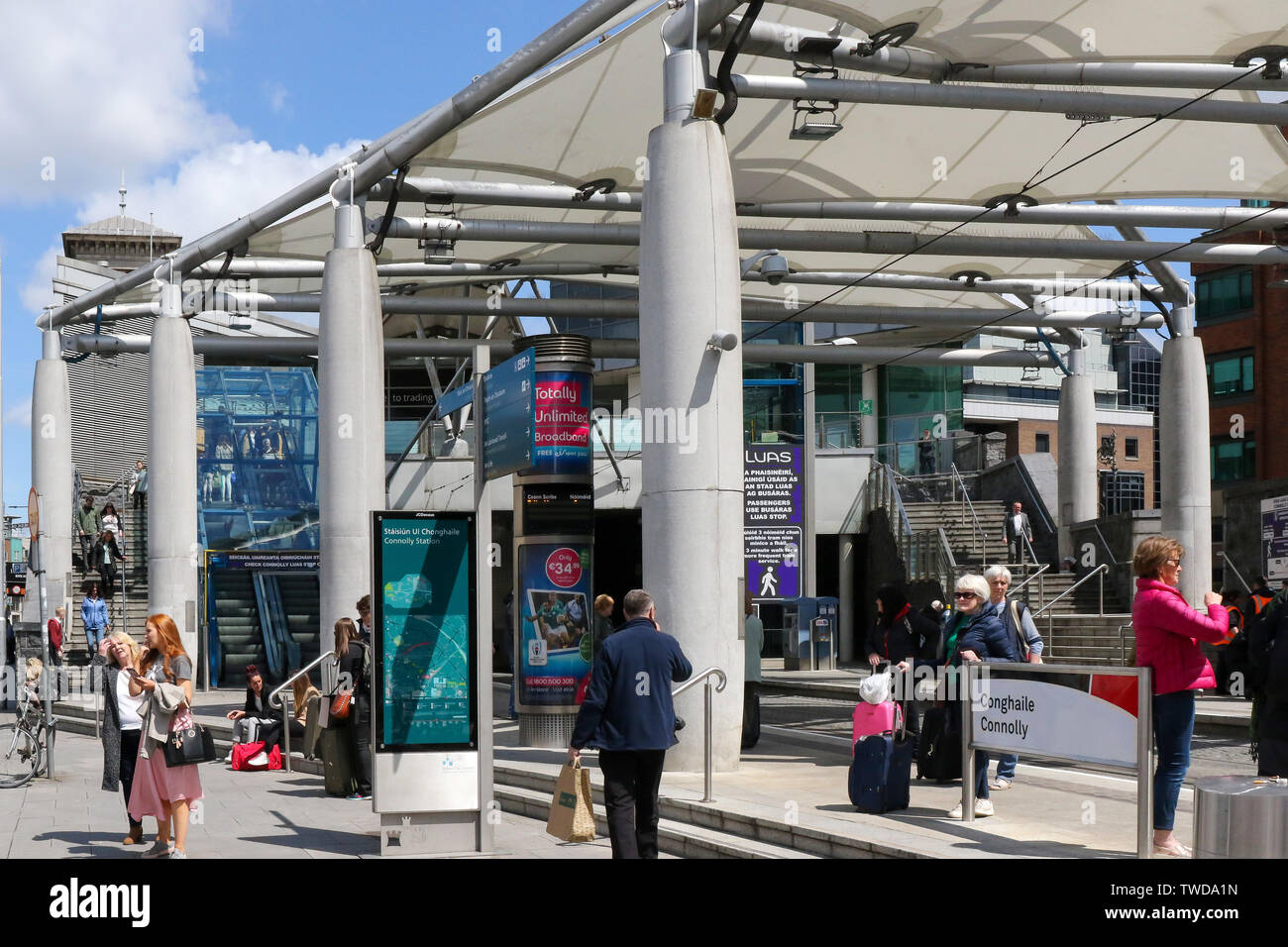 Dublin Street scene con le persone al Connolly LUAS fermare con il moderno ingresso a Connolly Station su una soleggiata giornata estiva a Dublino. Foto Stock