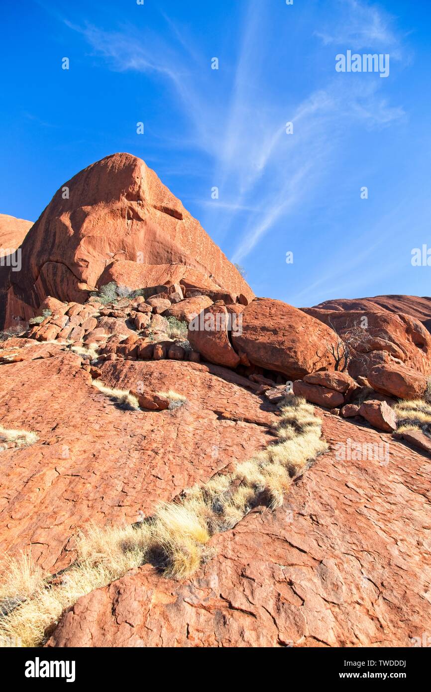 Il Red rock australiano del centro contro il cielo blu con nuvole wispy Foto Stock