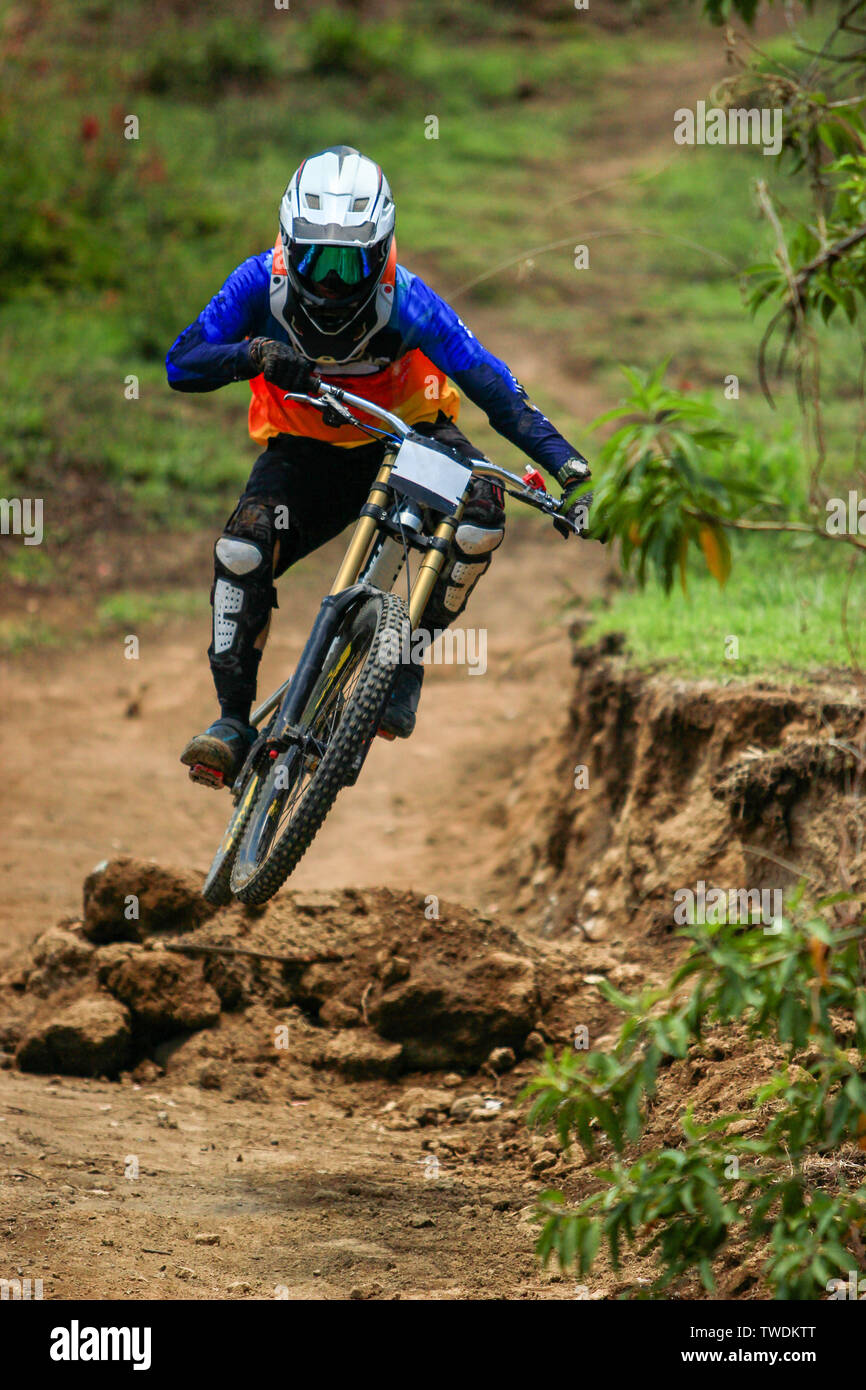 Un professionista di discesa il ciclista racer di salto e facendo strisciare sulla sua sospensione completa bici di carbonio Foto Stock