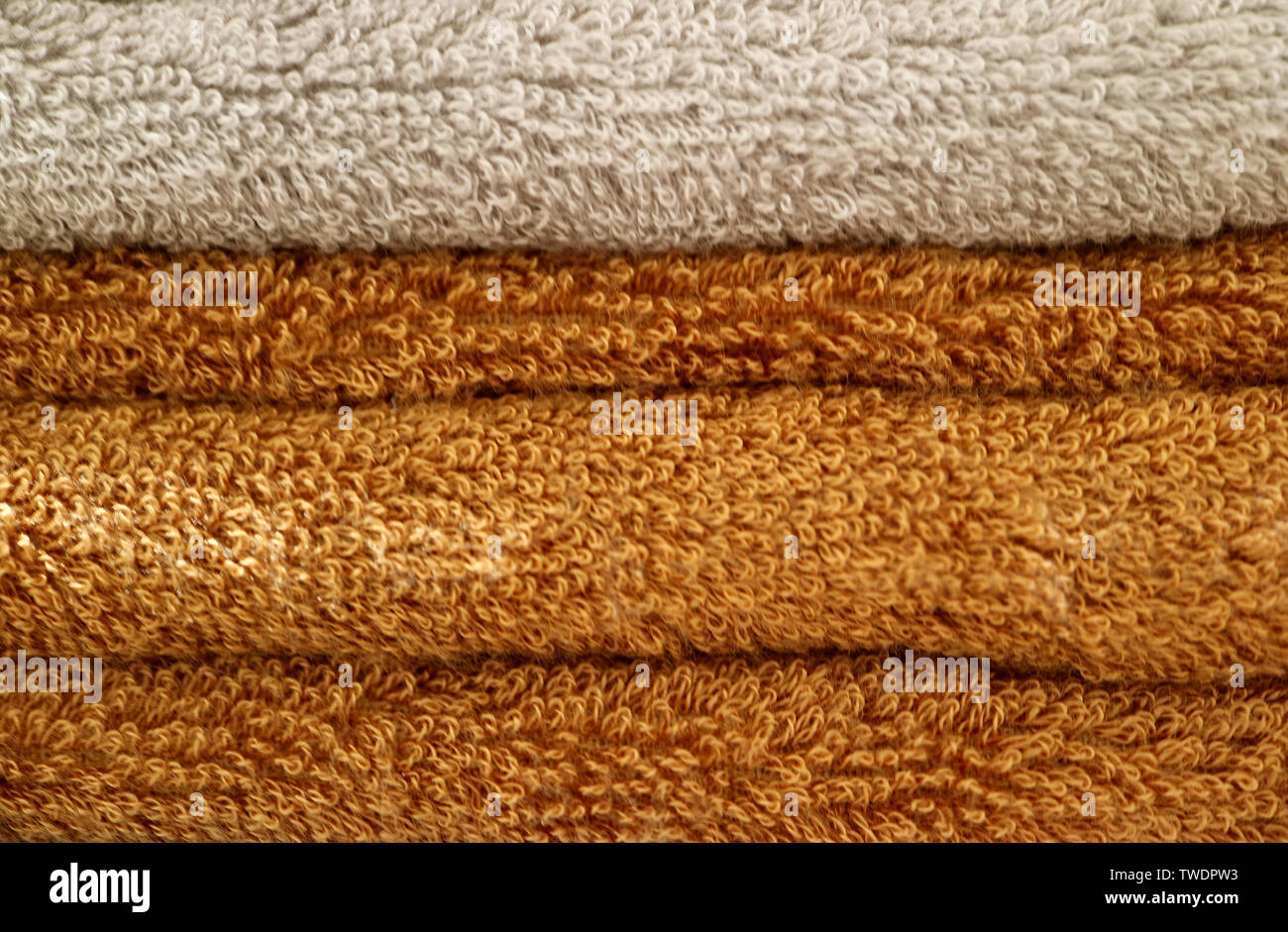 Pila di fogli piegati marrone e beige soffici asciugamani da bagno Foto Stock