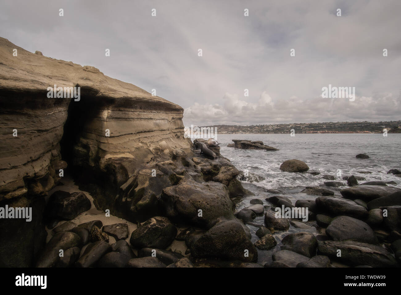 Giorno nuvoloso vista di una grotta rocciosa a La Jolla Beach in San Diego. Ja Jolla beach è un luogo popolare per i turisti a guardare i leoni di mare. Foto Stock