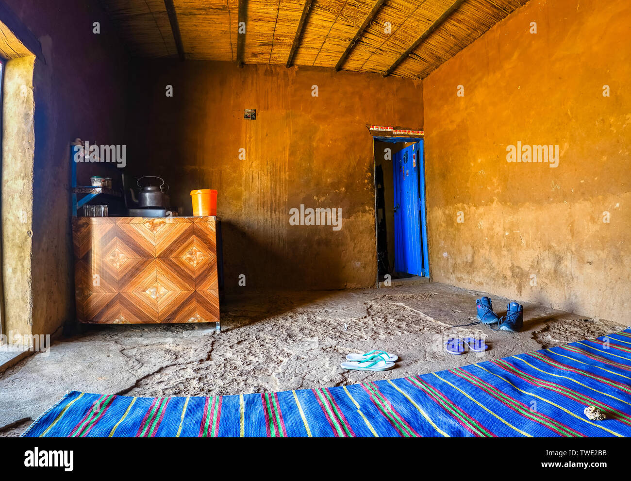 All'interno di una sosta nel deserto del Sudan con un tappeto blu e una stufa dove il cibo, il tè e il caffè sono preparati. Foto Stock