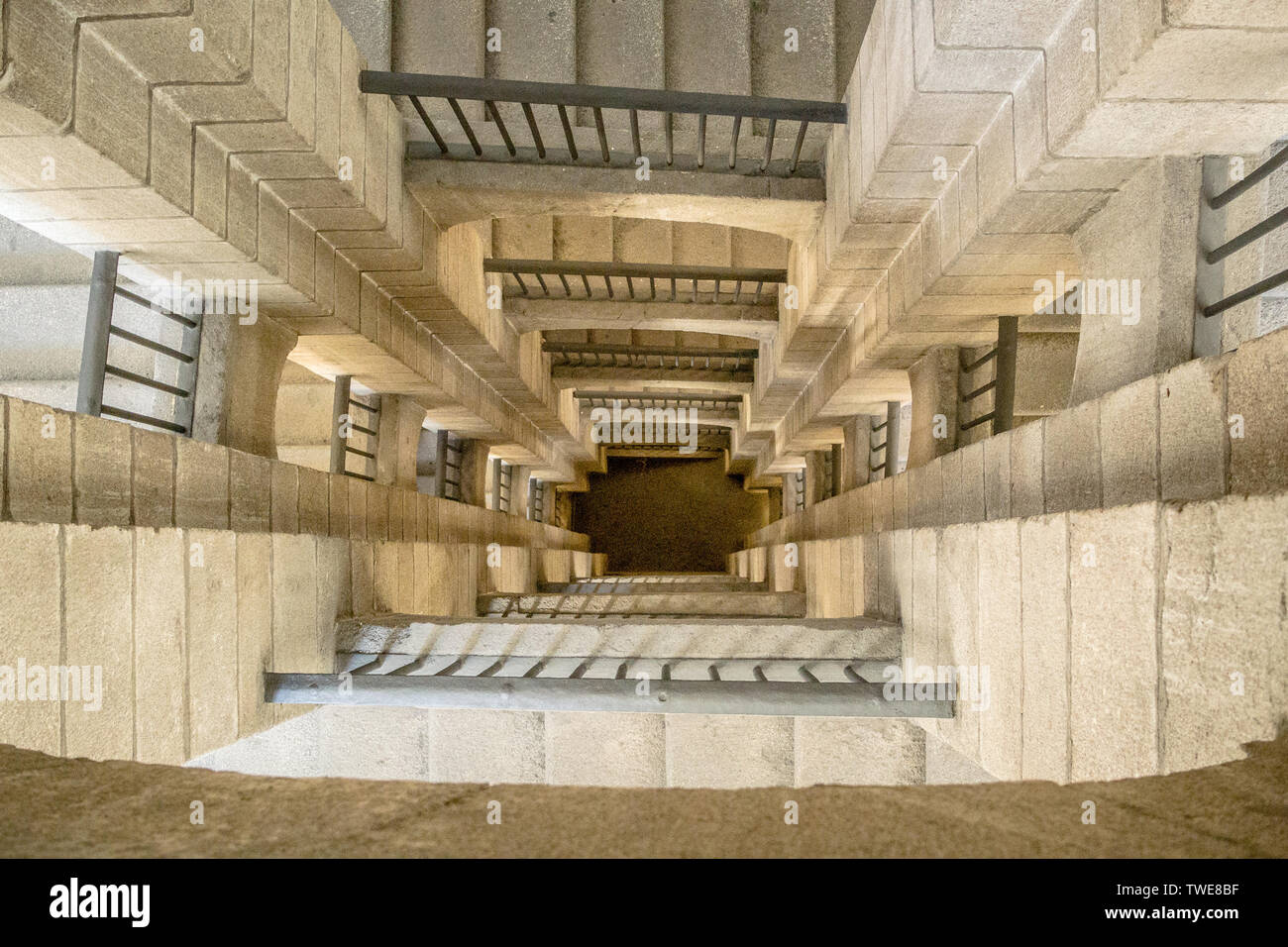 Guardando verso il basso di aprire a più piani con scala di pietra in un ex edificio dell ospedale, ora galleria d'arte, costruita nel 1805 a Madrid, Spagna. Foto Stock