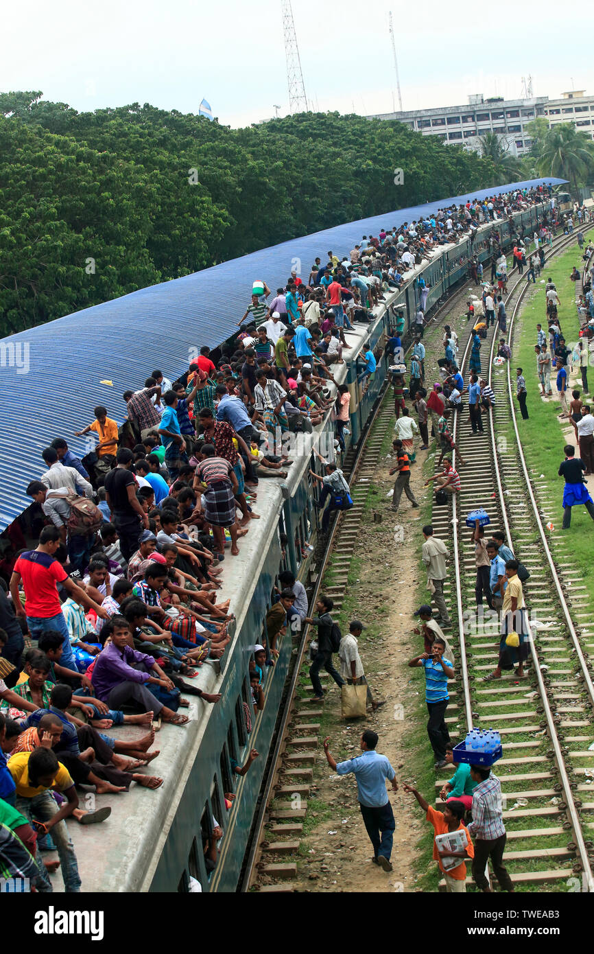 Home-bound le persone lottano per ottenere il tetto di un treno alla Stazione Ferroviaria Aeroportuale in anticipo di Eid-ul-Fitr. Dacca in Bangladesh. Foto Stock