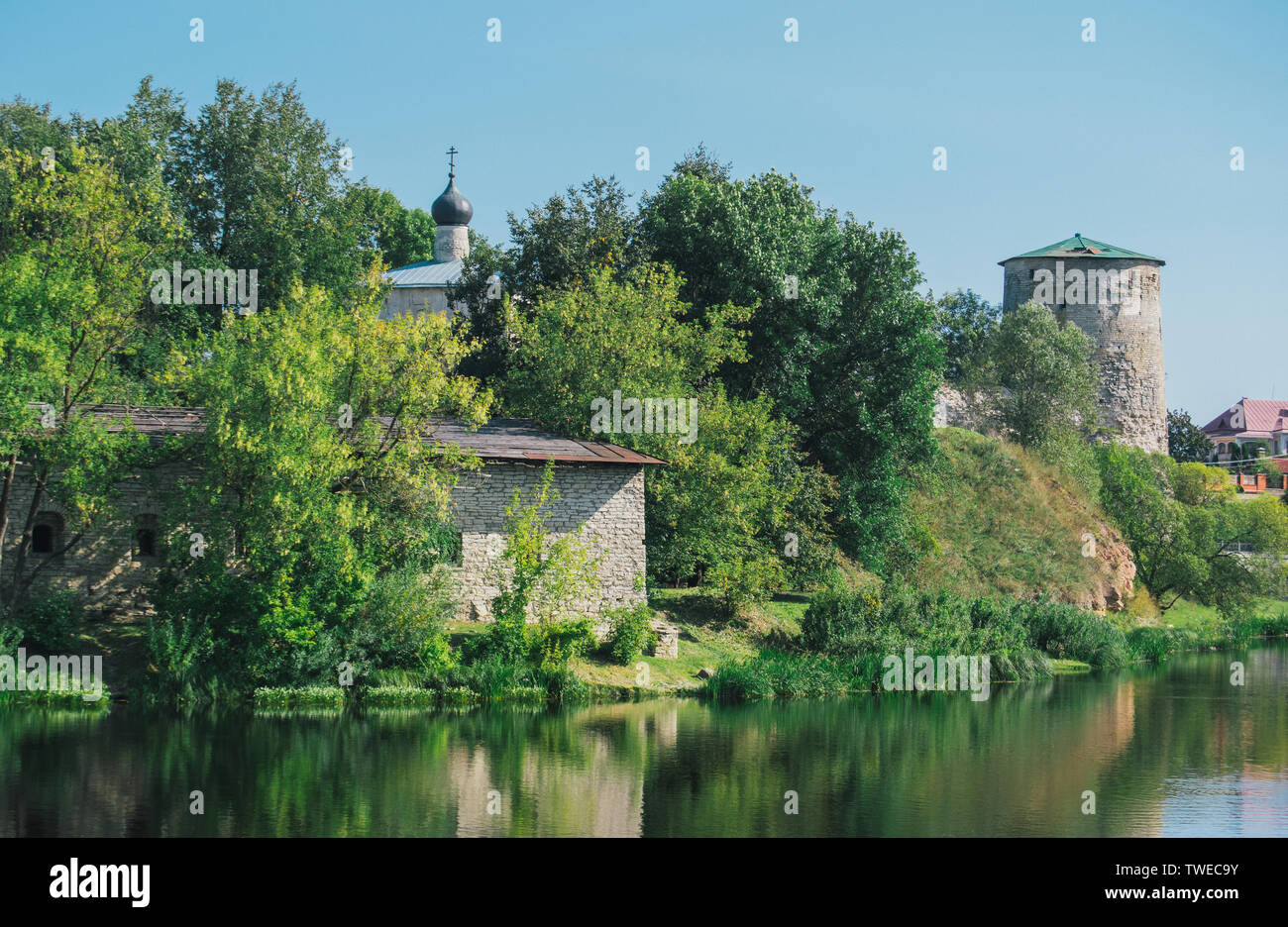 Paesaggio dalla chiesa e alberi verdi come pure il fiume nella città di Pskov Foto Stock