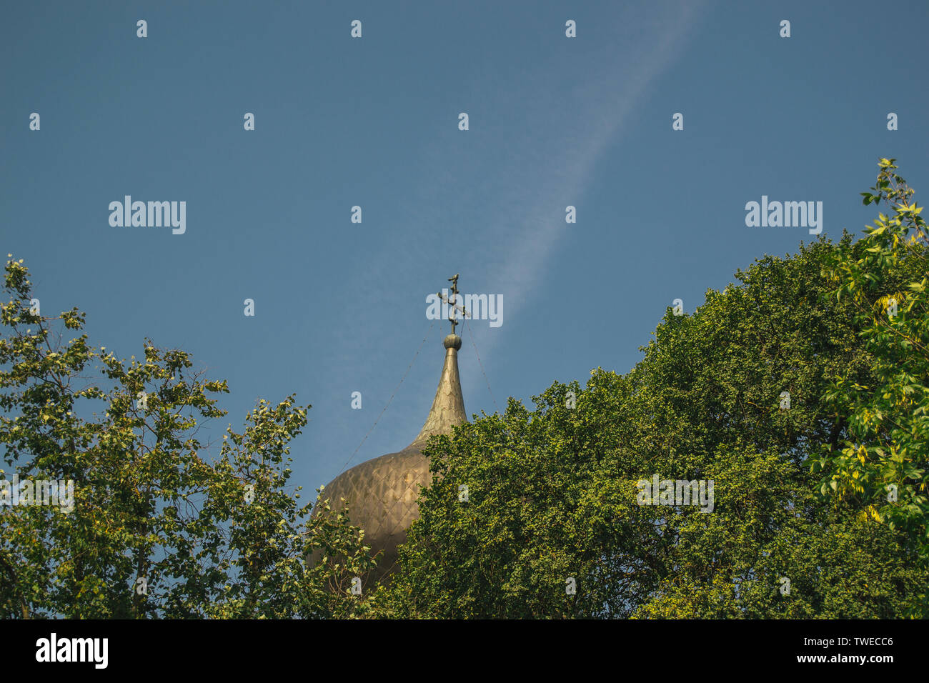 Chiesa cristiana cupola tra i rami degli alberi e sullo sfondo del cielo Foto Stock