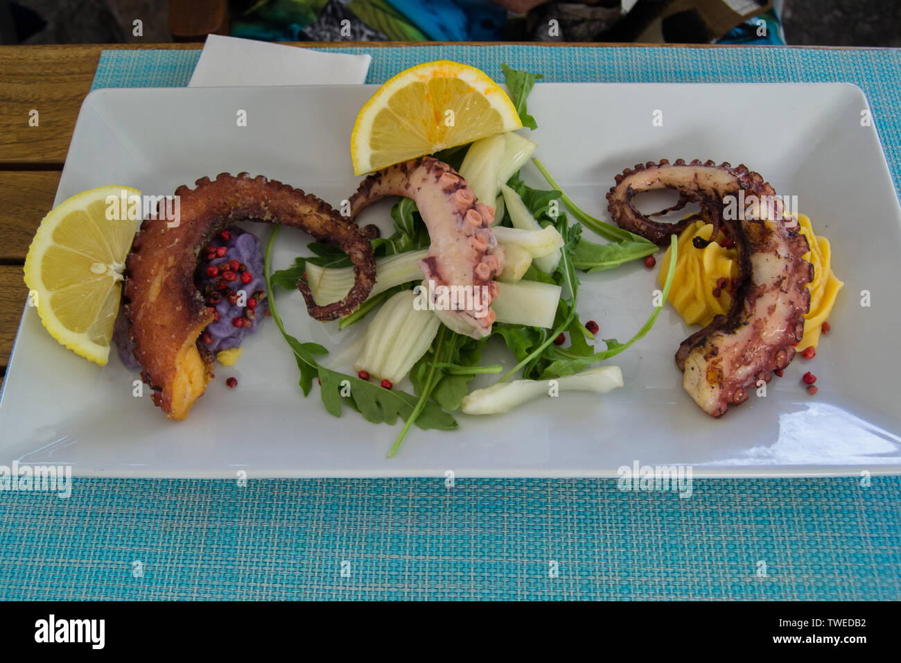 Splendidamente pasto servito in un bianco piatto a base di pesce in un ristorante Foto Stock