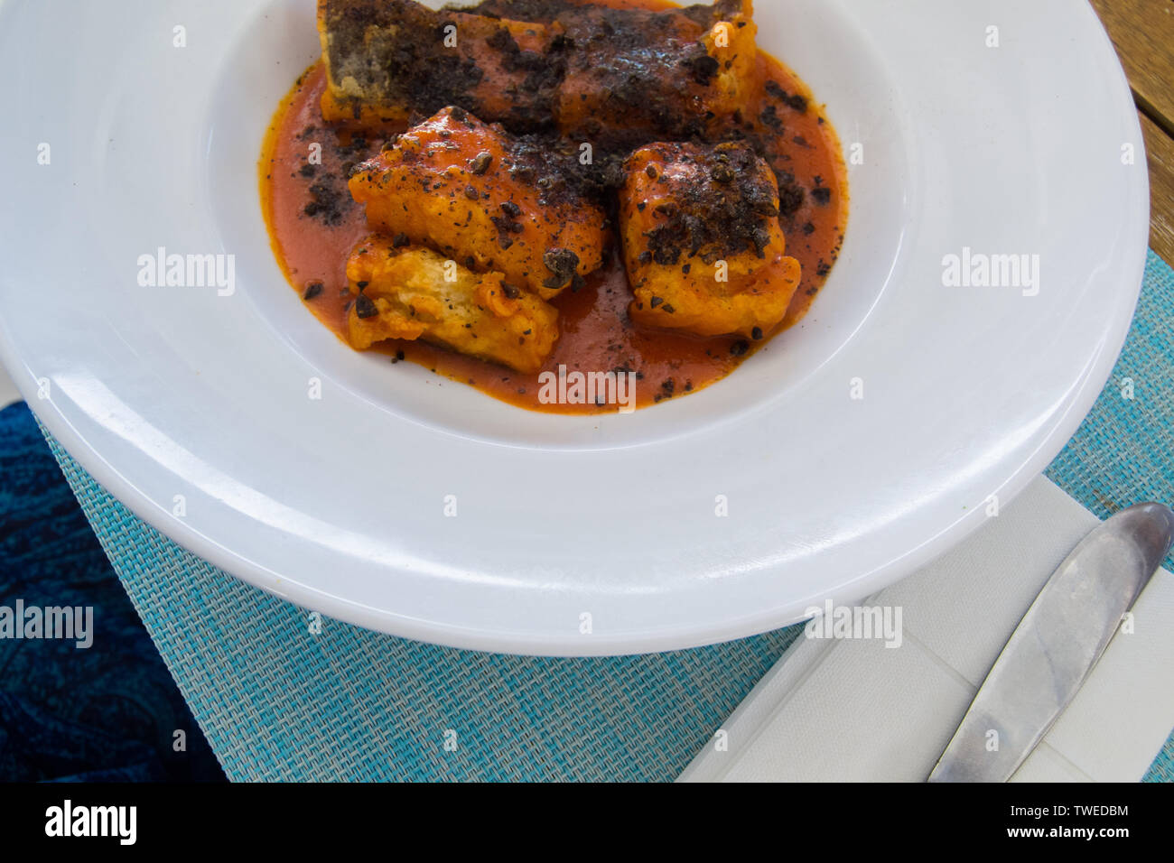 Splendidamente pasto servito in un bianco piatto a base di pesce in un ristorante Foto Stock