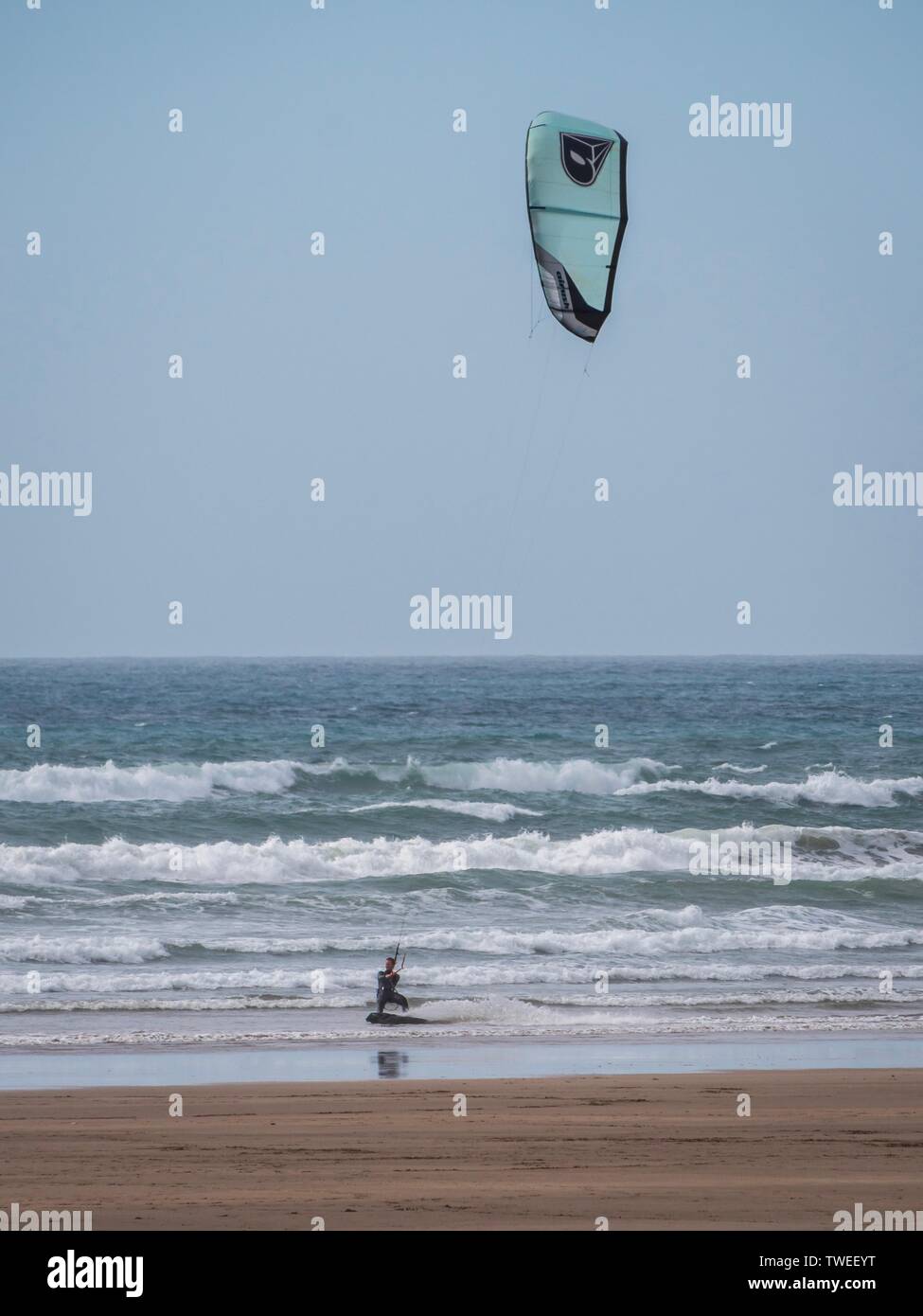 Un kiteboarder sul mare in una spiaggia poco profonda nel Devon, Regno Unito Foto Stock