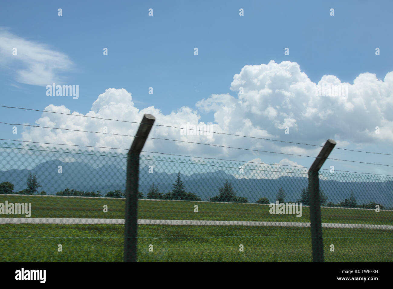 Recinzione chainlink con montagna sullo sfondo, Malesia Foto Stock
